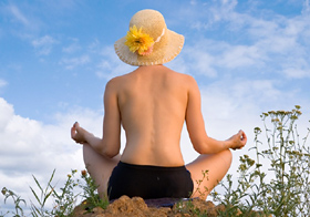 Frau mit Sonnenhut beim Yoga