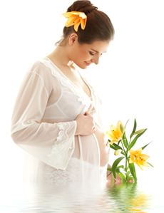 Schwangere Frau mit Blume im Haar